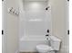 Bright bathroom featuring a white tiled shower-tub combination, black fixtures, and a matching white toilet at 1019 Null Rd, Lincolnton, NC 28092