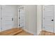 Bright hallway with hardwood floors featuring multiple white doors with matte black hardware at 1019 Null Rd, Lincolnton, NC 28092