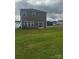 Exterior shot of backyard and house with vinyl siding and manicured lawn at 1022 Jeffery Dean Ct, Albemarle, NC 28001