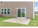 View of the rear exterior of the home featuring a concrete patio with sliding glass door and small grassy yard at 1022 Jeffery Dean Ct, Albemarle, NC 28001