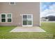 View of the rear exterior of the home with a concrete patio, siding, and small grassy yard at 1022 Jeffery Dean Ct, Albemarle, NC 28001
