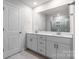 Bright bathroom featuring double vanity with stone countertop and tiled walk-in shower reflected in the mirror at 1022 Jeffery Dean Ct, Albemarle, NC 28001