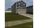 View of a two-story home featuring a two-car garage, gray siding, well-manicured lawn, and concrete driveway at 1022 Jeffery Dean Ct, Albemarle, NC 28001
