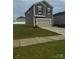 View of a two-story home featuring a two-car garage, gray siding, well-manicured lawn, and concrete driveway at 1022 Jeffery Dean Ct, Albemarle, NC 28001