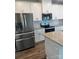 Bright kitchen featuring white cabinets, granite countertops, stainless steel appliances, and wood floors at 1022 Jeffery Dean Ct, Albemarle, NC 28001