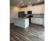 Bright kitchen featuring white cabinets, granite countertops, stainless steel appliances, and wood floors at 1022 Jeffery Dean Ct, Albemarle, NC 28001