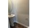 Half bathroom features pedestal sink, wood floors, and modern fixtures, adding convenience for guests at 1022 Jeffery Dean Ct, Albemarle, NC 28001