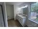 Bright bathroom boasts double sinks with granite counters, wood cabinets, and natural light at 11021 Scrimshaw Ln, Charlotte, NC 28215