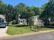 A well-maintained two-story home with a lush green lawn, mature trees, and a paved driveway at 11021 Scrimshaw Ln, Charlotte, NC 28215