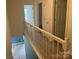 Upstairs hallway featuring a railing, doors, and hardwood flooring throughout at 11021 Scrimshaw Ln, Charlotte, NC 28215