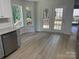 Bright eat-in kitchen features stainless steel dishwasher, gray cabinets, granite counters and door to deck at 11021 Scrimshaw Ln, Charlotte, NC 28215