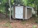 View of the backyard shed with painted white double doors and brown siding at 11021 Scrimshaw Ln, Charlotte, NC 28215