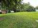 Spacious backyard with mature trees, a grassy area, and a small shed at 111 Rose St, Mount Holly, NC 28120