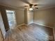 Bedroom with wood-look flooring, ceiling fan, closet with doors, and a view of an adjacent bathroom at 111 Rose St, Mount Holly, NC 28120