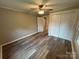 Bedroom featuring wood-look flooring, a ceiling fan, closet with doors, and access to other rooms at 111 Rose St, Mount Holly, NC 28120