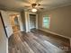 Bedroom showcasing wood-look floors, ceiling fan, closet with doors, and natural light from a window at 111 Rose St, Mount Holly, NC 28120