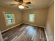 Cozy bedroom featuring neutral walls, wood-look flooring, ceiling fan, and natural light from two windows at 111 Rose St, Mount Holly, NC 28120