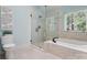 Bright bathroom featuring a glass-enclosed shower, soaking tub, and modern fixtures at 1140 Iverleigh Trl, Charlotte, NC 28270