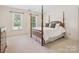 Bright bedroom with a four-poster bed, neutral carpet, and ample natural light from the windows at 1140 Iverleigh Trl, Charlotte, NC 28270