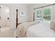 Bedroom with a four-poster bed, neutral decor, and a large window at 1140 Iverleigh Trl, Charlotte, NC 28270