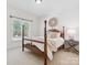 Comfortable bedroom with a four-poster bed, soft carpet, and natural light at 1140 Iverleigh Trl, Charlotte, NC 28270