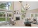 Bright living room boasts soaring ceilings, fireplace, large windows, and elegant chandelier at 1140 Iverleigh Trl, Charlotte, NC 28270