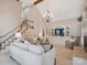 Inviting living room featuring a staircase, built ins, high ceilings, and a beautiful chandelier at 1140 Iverleigh Trl, Charlotte, NC 28270