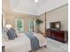 Comfortable main bedroom features a four-poster bed, large windows, and a TV at 1140 Iverleigh Trl, Charlotte, NC 28270