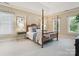 Comfortable main bedroom features a four-poster bed, large windows, and neutral decor at 1140 Iverleigh Trl, Charlotte, NC 28270