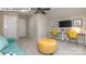 Open bonus room with a turquoise sofa, yellow ottoman, desk area, and neutral carpeting at 135 Asmodean Ln, Troutman, NC 28166