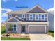 Charming two-story home featuring stone accents, a two-car garage, and a well-manicured lawn at 139 Asmodean Ln, Troutman, NC 28166
