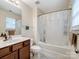 Bright bathroom features a shower and vanity with wood cabinets at 13909 Singleleaf Ln, Charlotte, NC 28278
