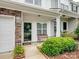 Inviting front porch featuring a bench, manicured landscaping, and stone accents on the townhome at 13909 Singleleaf Ln, Charlotte, NC 28278