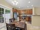 Eat-in kitchen boasts stainless appliances, wood cabinets, granite counters, and sliding doors to the rear patio at 13909 Singleleaf Ln, Charlotte, NC 28278