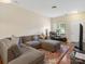 Comfortable living room featuring hardwood floors, a large sectional sofa, and ample natural light at 13909 Singleleaf Ln, Charlotte, NC 28278