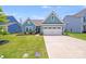 Charming blue two-story home with a well-manicured lawn and two car garage at 1391 Links Crossing Dr, Monroe, NC 28112