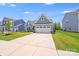Charming blue home boasts a well-kept lawn and a convenient two-car garage at 1391 Links Crossing Dr, Monroe, NC 28112