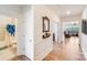 Hallway with hardwood floors, decorative mirror, and access to bathroom and living room at 1391 Links Crossing Dr, Monroe, NC 28112