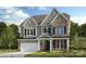 Charming two-story home with stone and siding exterior, a covered porch, and a two car garage at 1487 Hubert Graham Way, Tega Cay, SC 29708