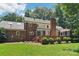 View of the beautiful brick exterior and backyard, featuring a deck, screened porch, and lush green lawn at 1545 Chadmore Nw Ln, Concord, NC 28027