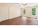 Bedroom with wood floors, two large windows, and closet with sliding doors at 1545 Chadmore Nw Ln, Concord, NC 28027