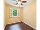 Bright bedroom features hardwood floors, a ceiling fan, and a window with natural light at 1545 Chadmore Nw Ln, Concord, NC 28027