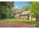 Stately brick home features manicured lawn, complemented by a beautiful landscape and mature trees at 1545 Chadmore Nw Ln, Concord, NC 28027
