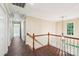 Upstairs hallway with chandelier, wood floors, and natural light from window at end of staircase at 1545 Chadmore Nw Ln, Concord, NC 28027