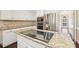 Kitchen island featuring a granite countertop, cooktop, and stainless steel refrigerator at 1545 Chadmore Nw Ln, Concord, NC 28027
