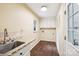 Laundry room with tile backsplash, utility sink, and white cabinets at 1545 Chadmore Nw Ln, Concord, NC 28027