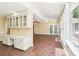 Open living room with hardwood floors, built-in cabinets, and a fireplace, connecting to the sunroom at 1545 Chadmore Nw Ln, Concord, NC 28027