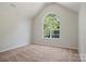 Bright bedroom featuring a large arched window and neutral carpet at 19010 Oakhurst Blvd, Cornelius, NC 28031