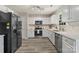 Modern kitchen with stainless steel appliances, white cabinets, and tile backsplash at 19010 Oakhurst Blvd, Cornelius, NC 28031