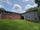 A well-maintained backyard featuring a lush green lawn and the home's exterior with a brick and gray siding at 2116 Dana Pl, Shelby, NC 28152